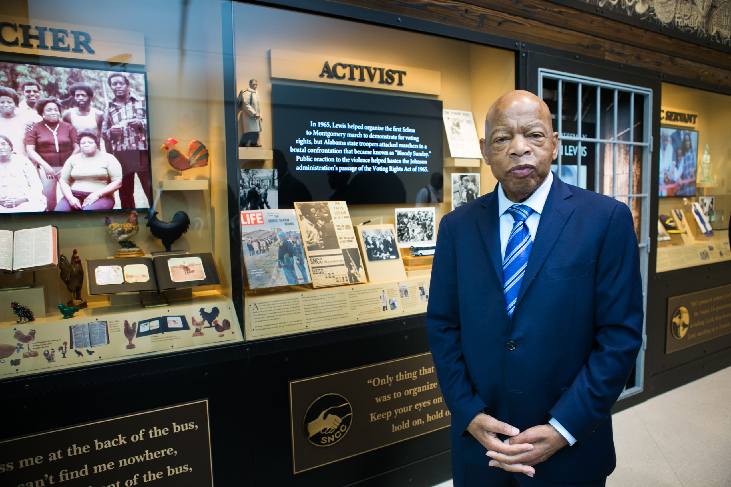 Congressman John Lewis standing in front of tribute wall