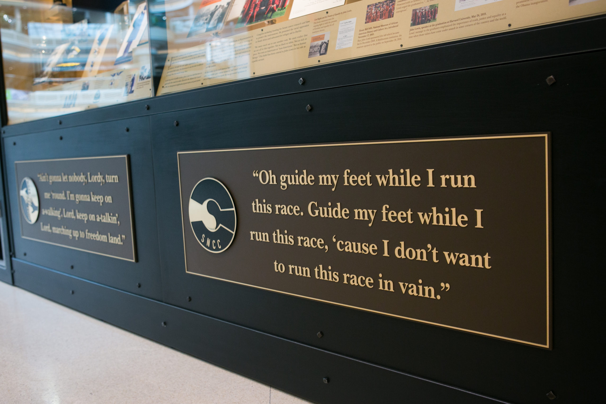 Bronze plaques at the foot of "John Lewis: Good Trouble," embossed with lyrics to civil rights songs.